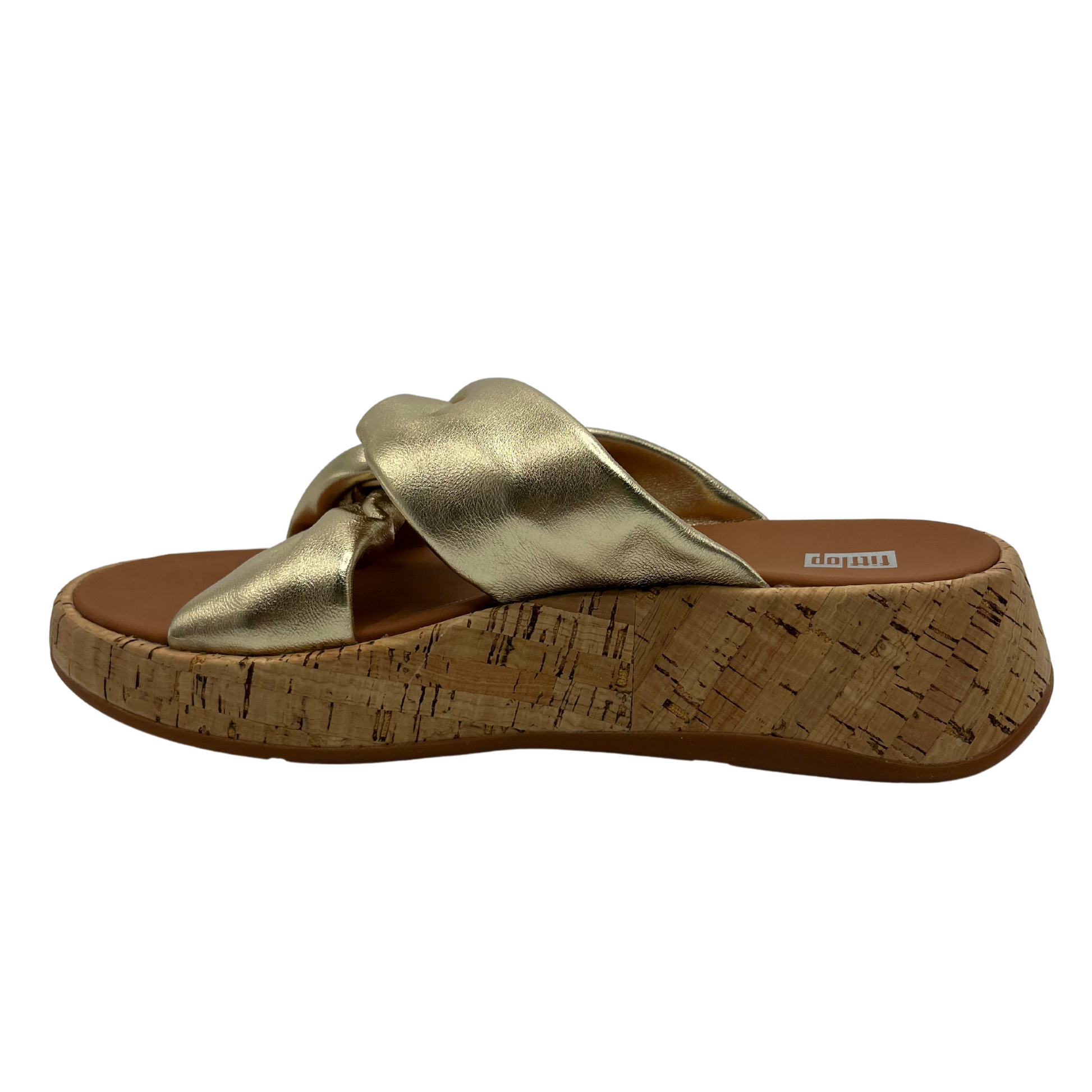 Left facing view of gold leather strapped sandal with thick platform sole and knot detail