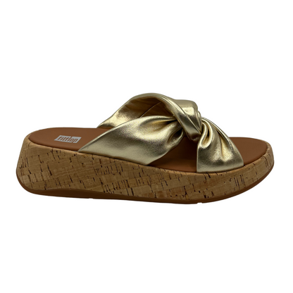 Right facing view of gold leather strapped sandal with thick platform sole and knot detail