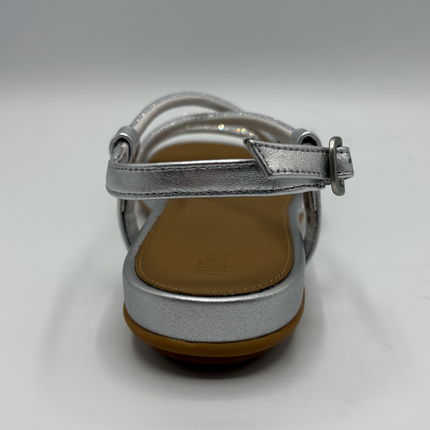 Silver sandal with a brown sole on a white background