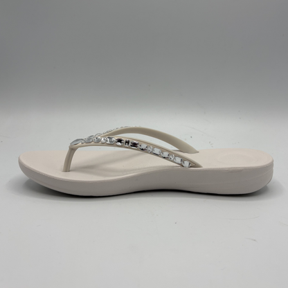 Beige sandal with a decorative strap on a gray background