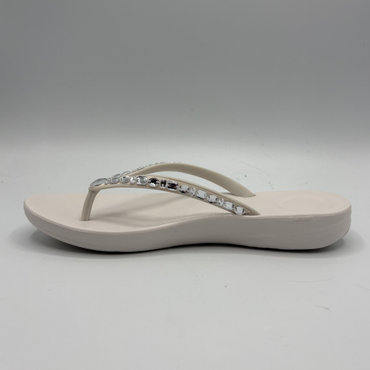 Beige sandal with a decorative strap on a gray background