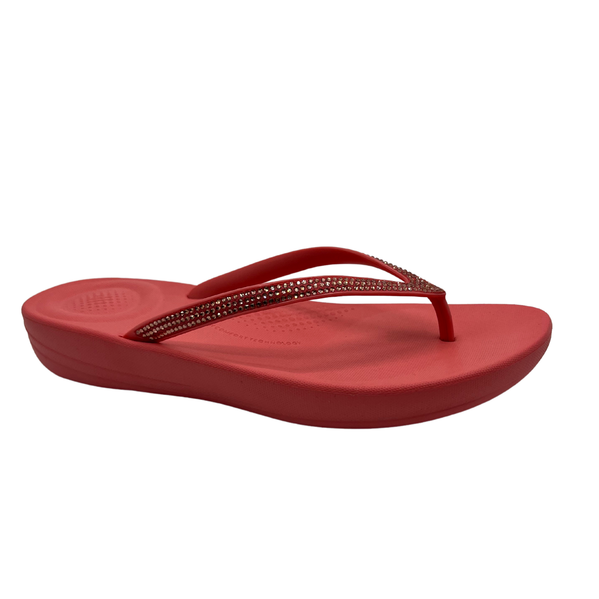 45 degree angled view of rosy coral flip flop with bejewelled thong strap