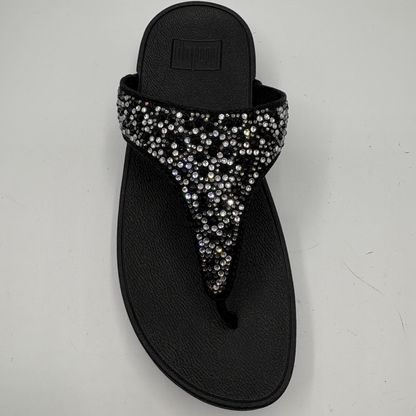 Black sandal with rhinestone embellishments on a light gray background