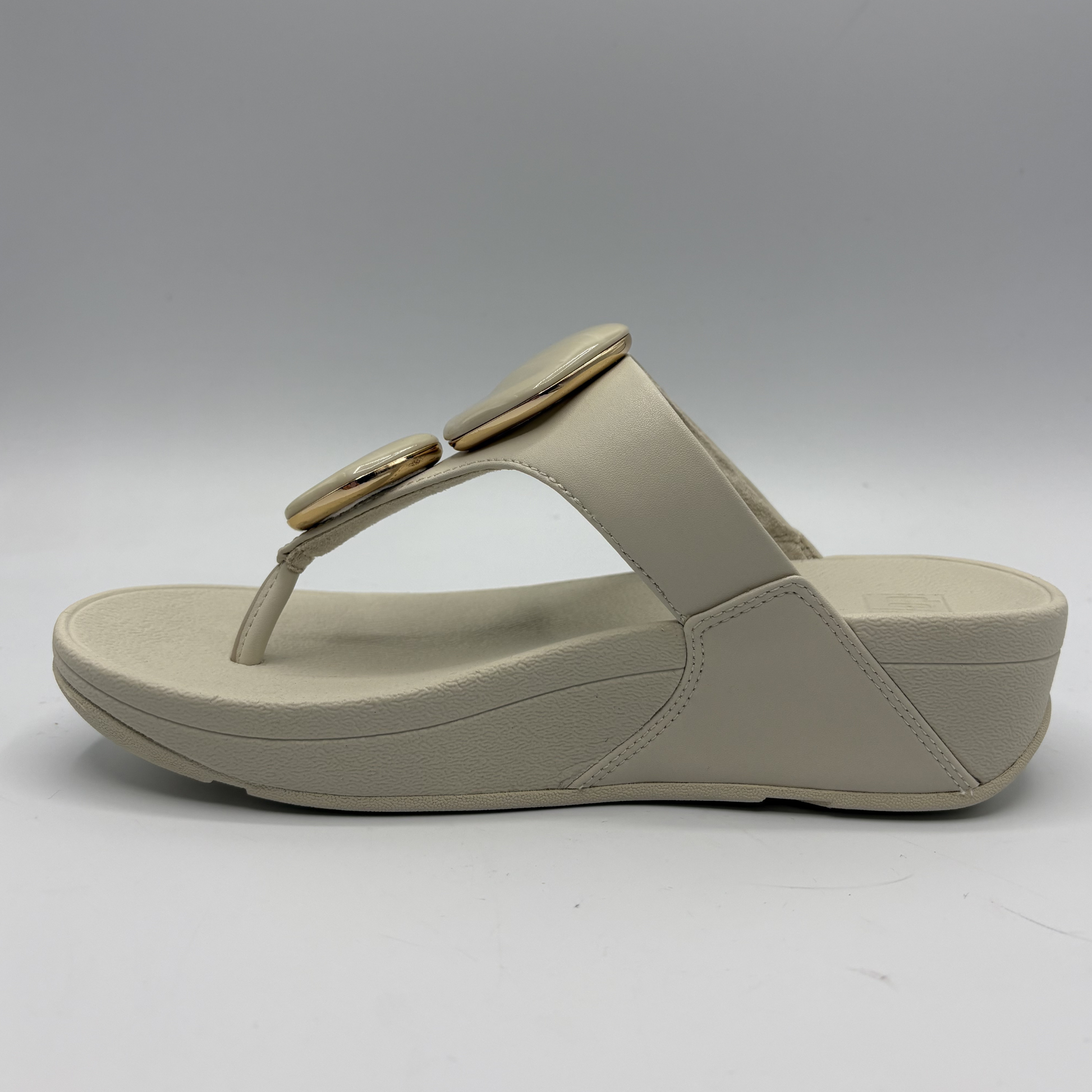 Beige sandal with a wedge heel on a white background