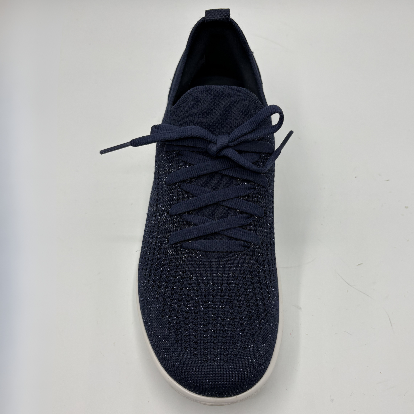 Navy blue sneaker with white sole on a light gray background