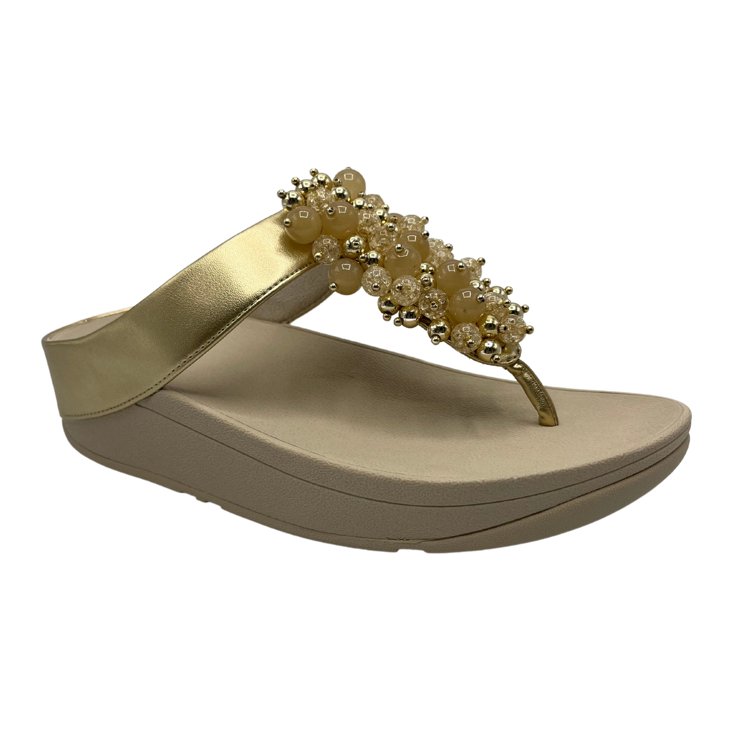 45 degree angled view of gold sandals with round embellishments on front strap and lightweight platform sole