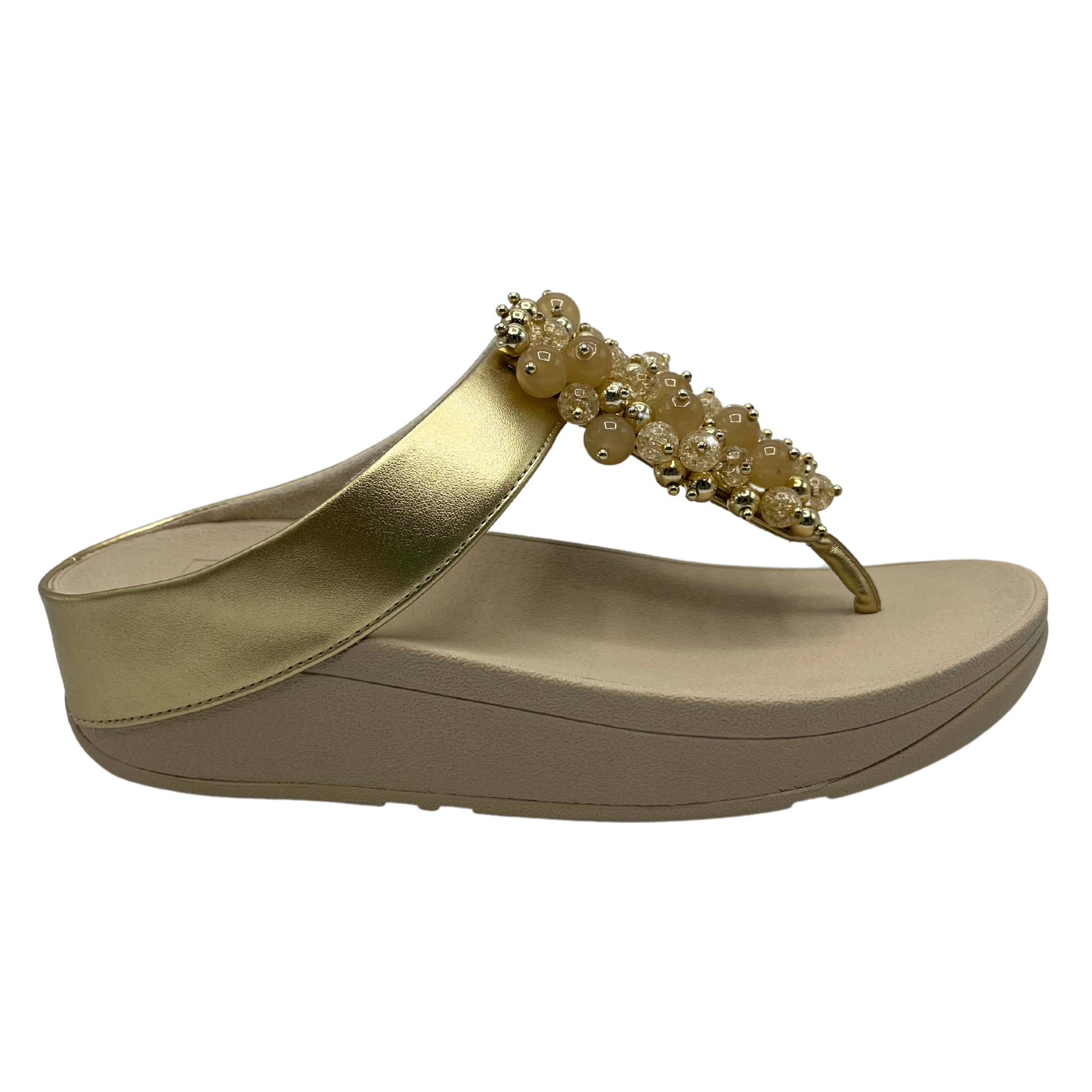 Right facing view of gold sandals with round embellishments on front strap and lightweight platform sole