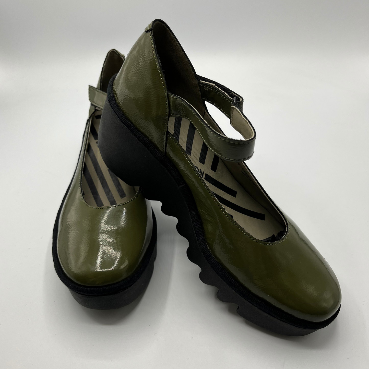 Pair of green shoes with black soles on a white background