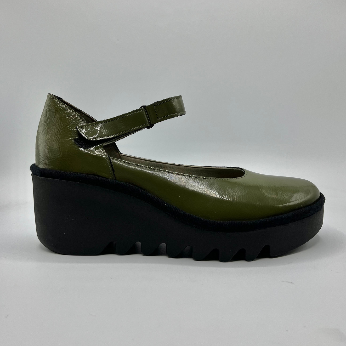 Green shoe with a thick black sole on a white background