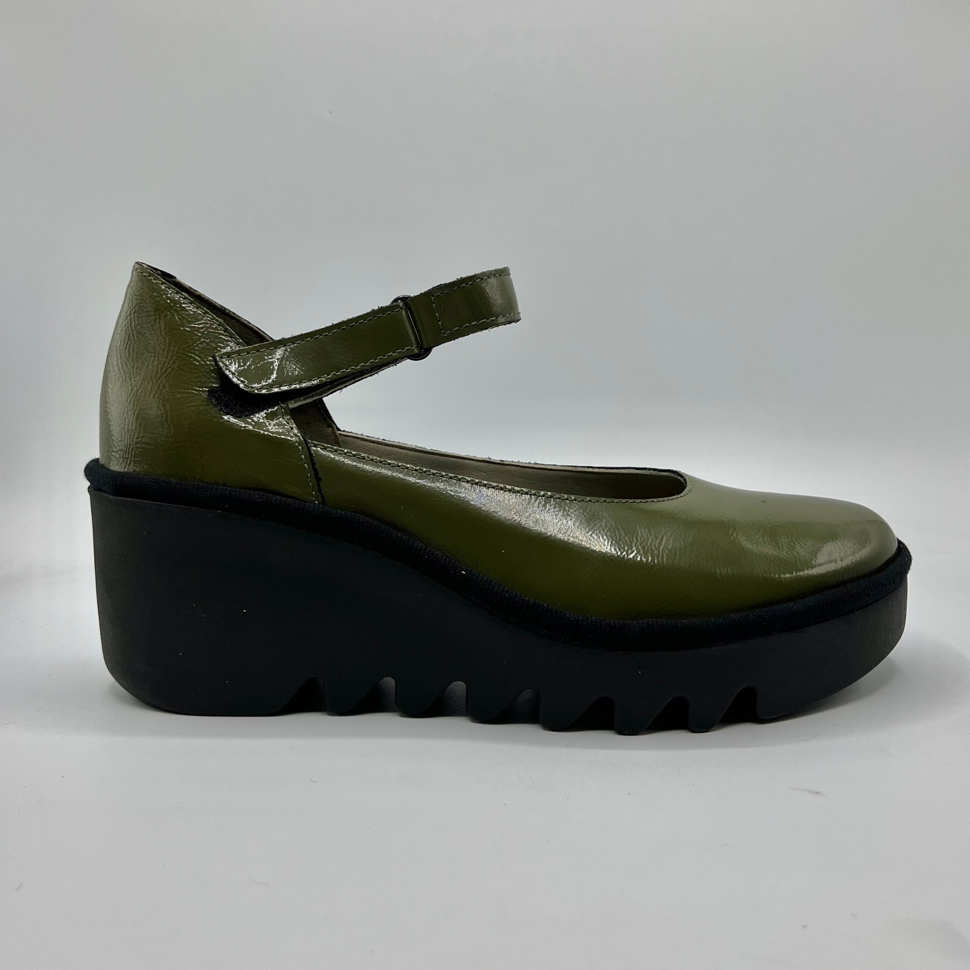 Green shoe with a thick black sole on a white background
