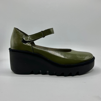 Green shoe with a thick black sole on a white background