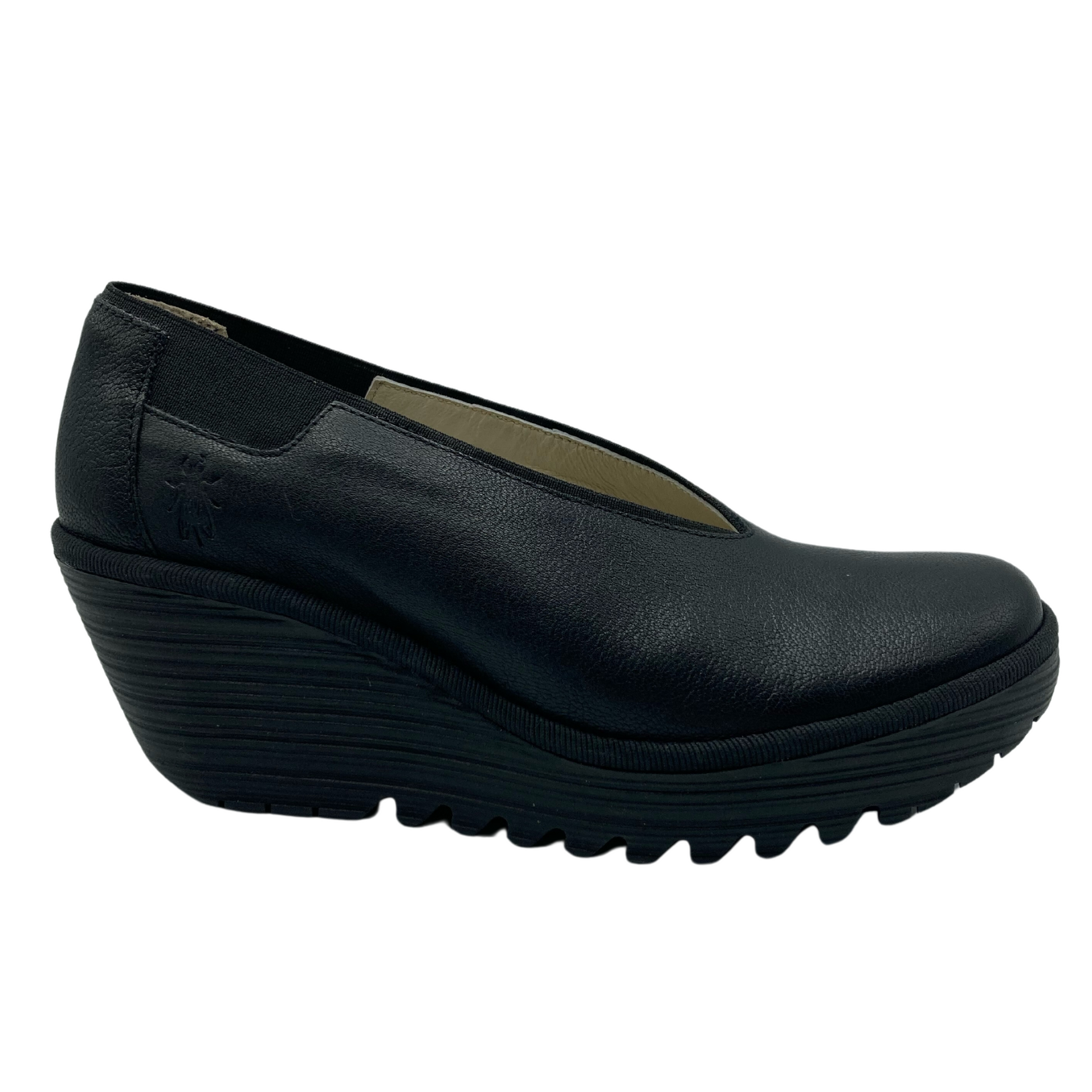 Side view of wedge shoe with black leather upper