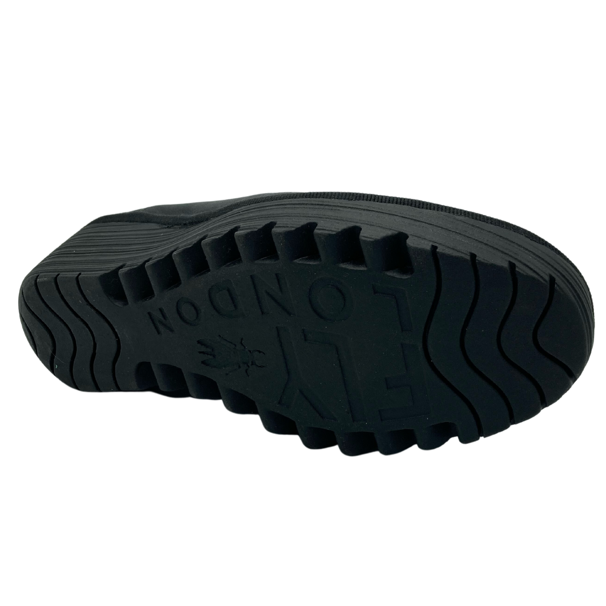 View of the bottom of the wedge shoe with black rubber tread