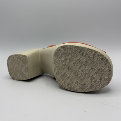 Close-up of a shoe sole with brand logo on a gray background
