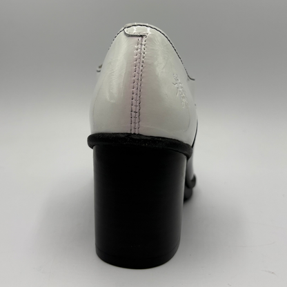 A close-up rear view of a women's block-heel shoe with a glossy white patent leather upper and a chunky black block heel, set against a neutral gray background.