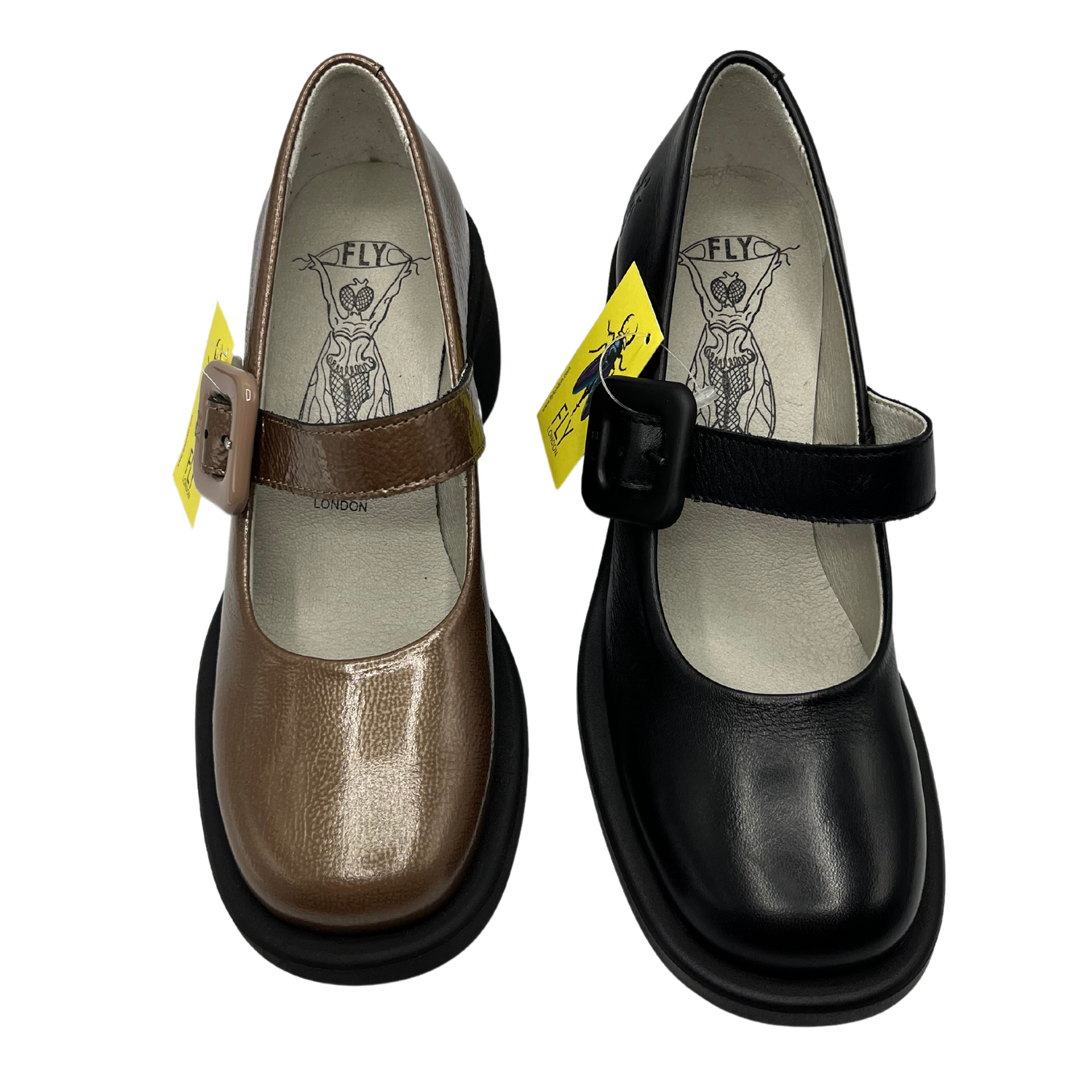 Top view of a pair of maryjane shoes. One is taupe patent leather and the other is black leather. Both have matching buckles and a rounded toe.