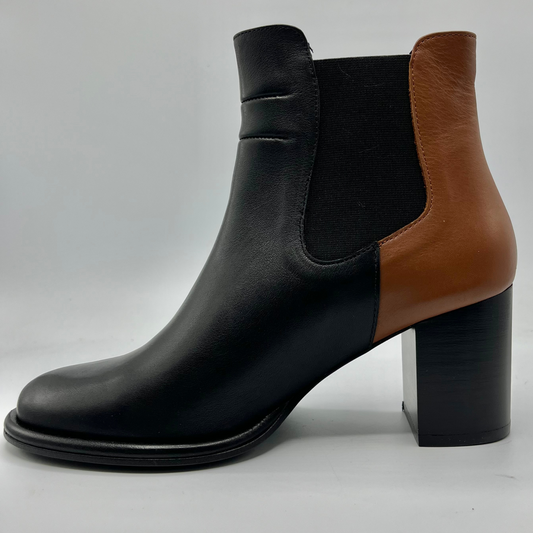 Black and brown ankle boot with a block heel on a light gray background
