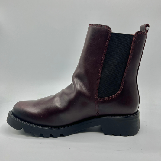 Wine leather boot with a black sole on a light gray background