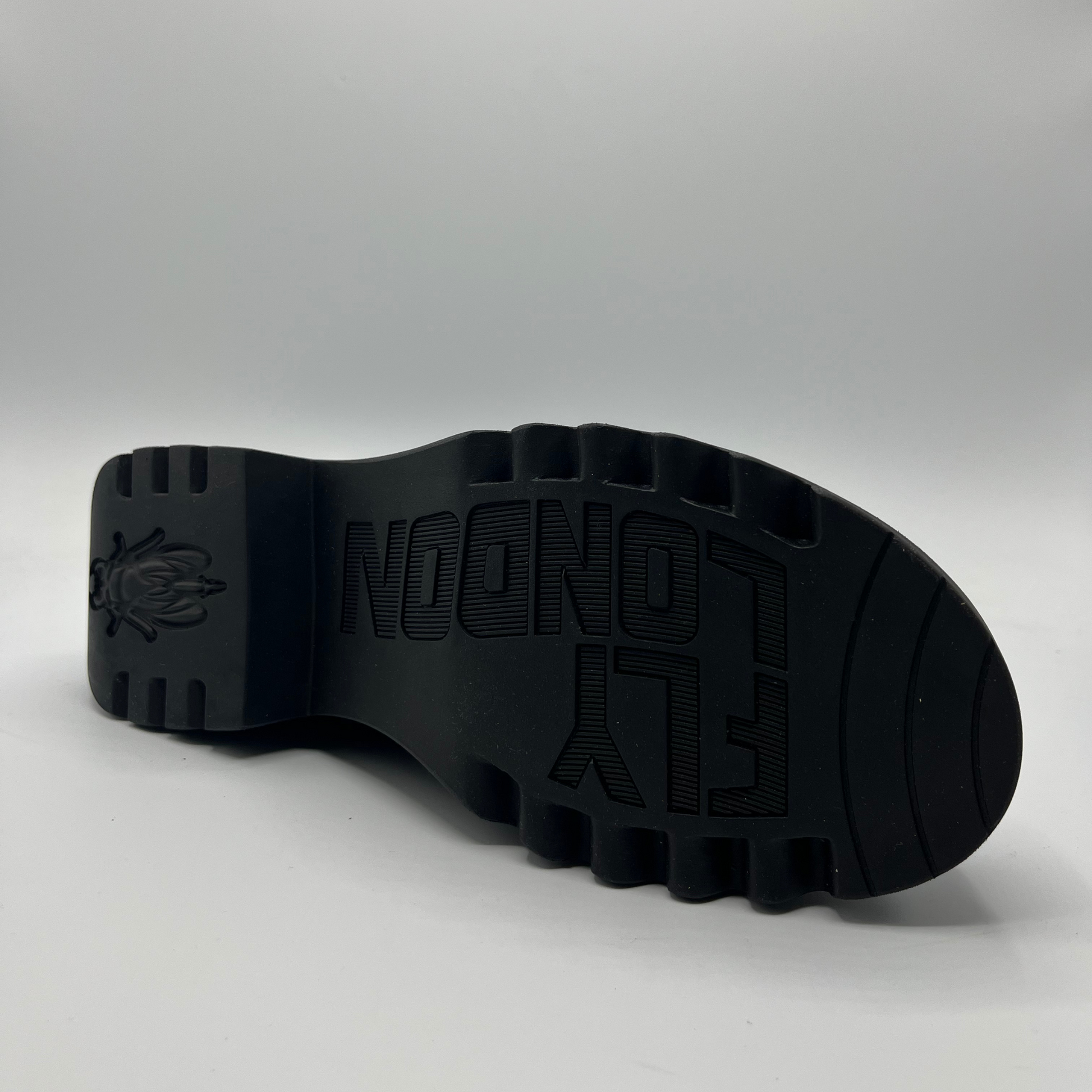 Black sole of a shoe with branding on a gray background