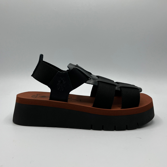 Right facing view of a black sandal with elastic straps and thick platform outsole.