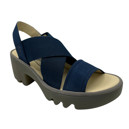 45 degree angled view of navy blue stretchy strapped sandal with lugged rubber outsole and rounded toe