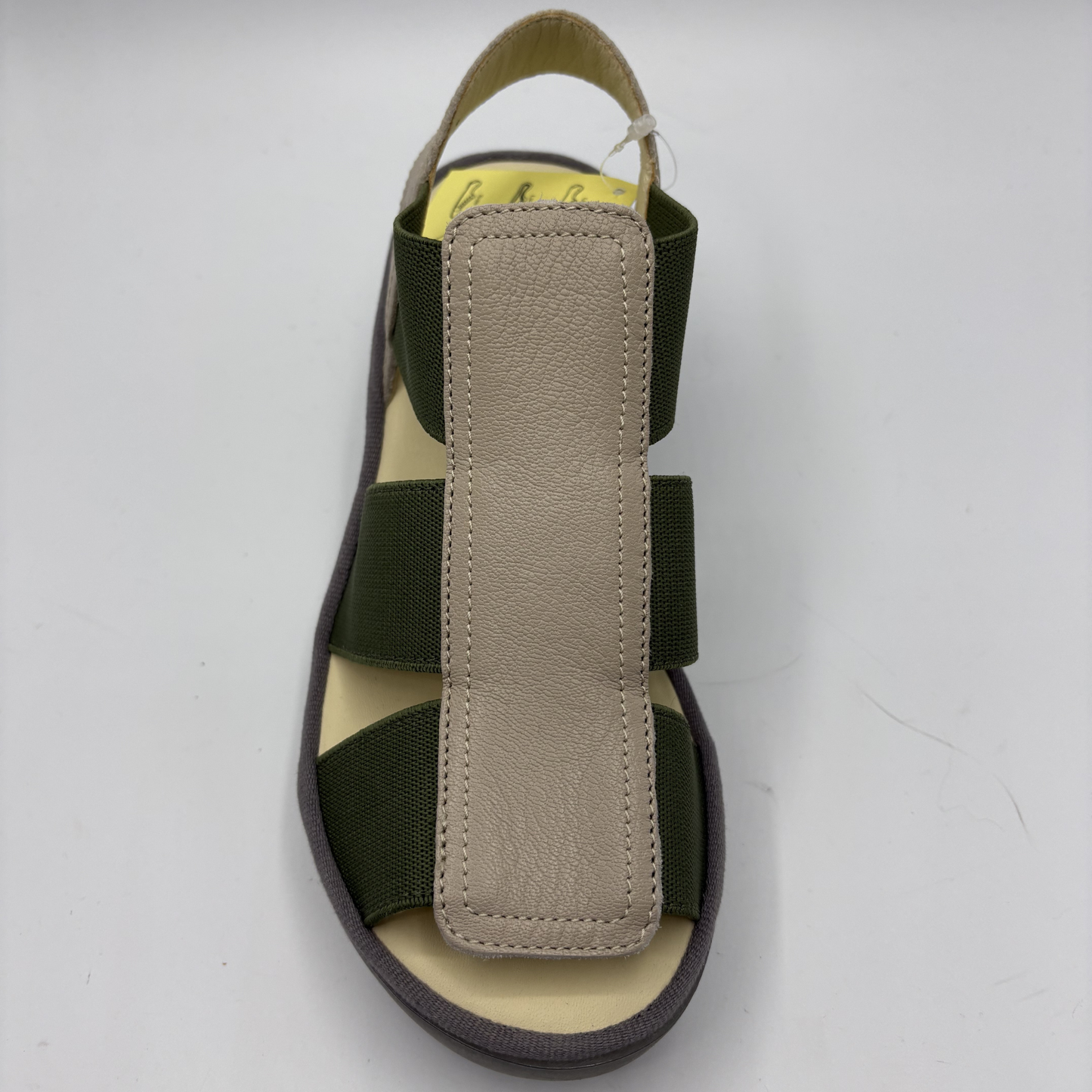 Sandal with beige insole and green straps on a white background