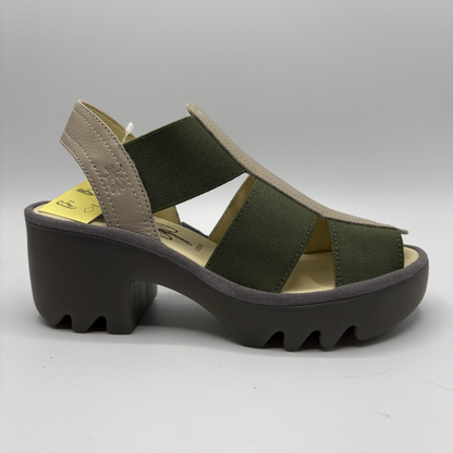 Green sandal with a thick black sole on a gray background
