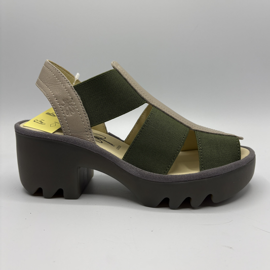 Green sandal with a thick black sole on a gray background
