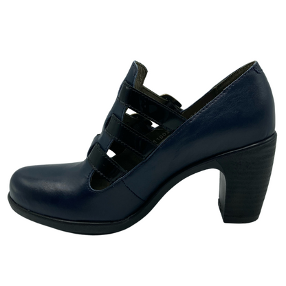 Left facing view of navy leather shoe with rounded toe and 3 black straps on upper. Black sole with black heel