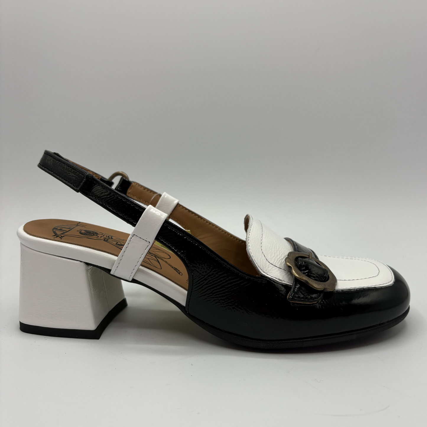 Black and white shoe with a block heel on a gray background