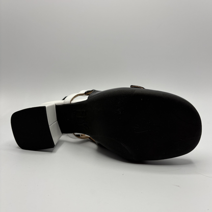 Black sandal with a white strap on a gray background