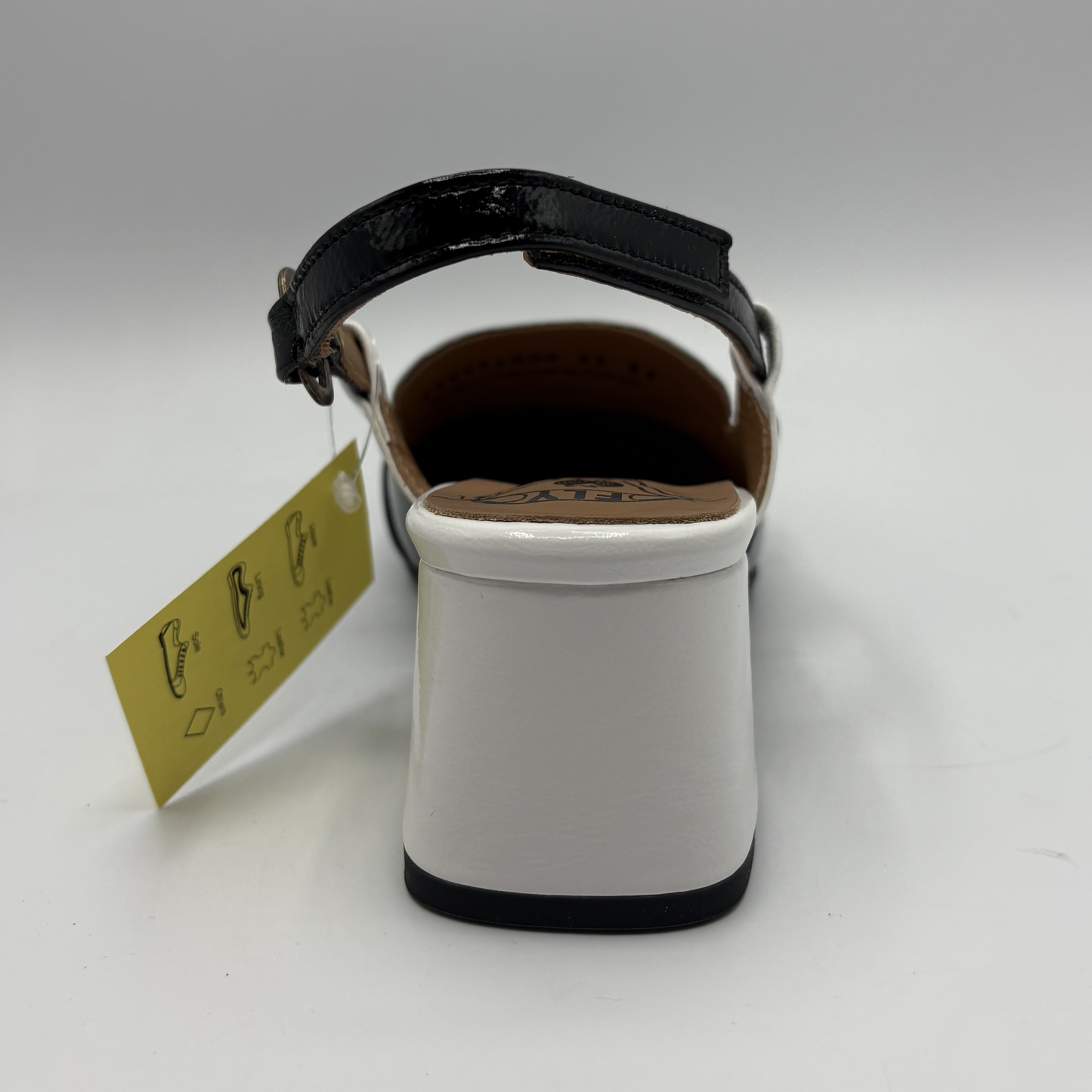 White sandal with black strap on a white background