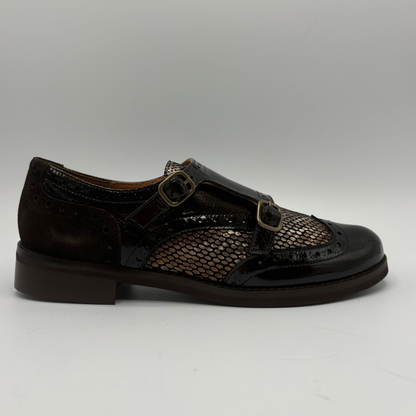 Right facing view of a shoe with a low heel, leather upper and decorative gold buckles on a white background