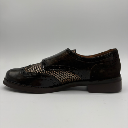 Left facing view of a shoe with a low heel, leather upper and decorative gold buckles on a white background