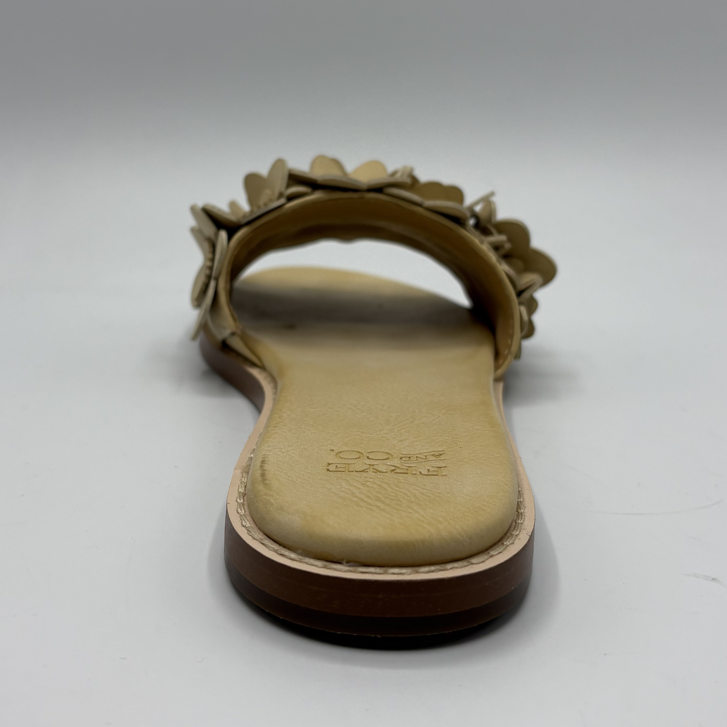 Beige sandal with floral design on a white background