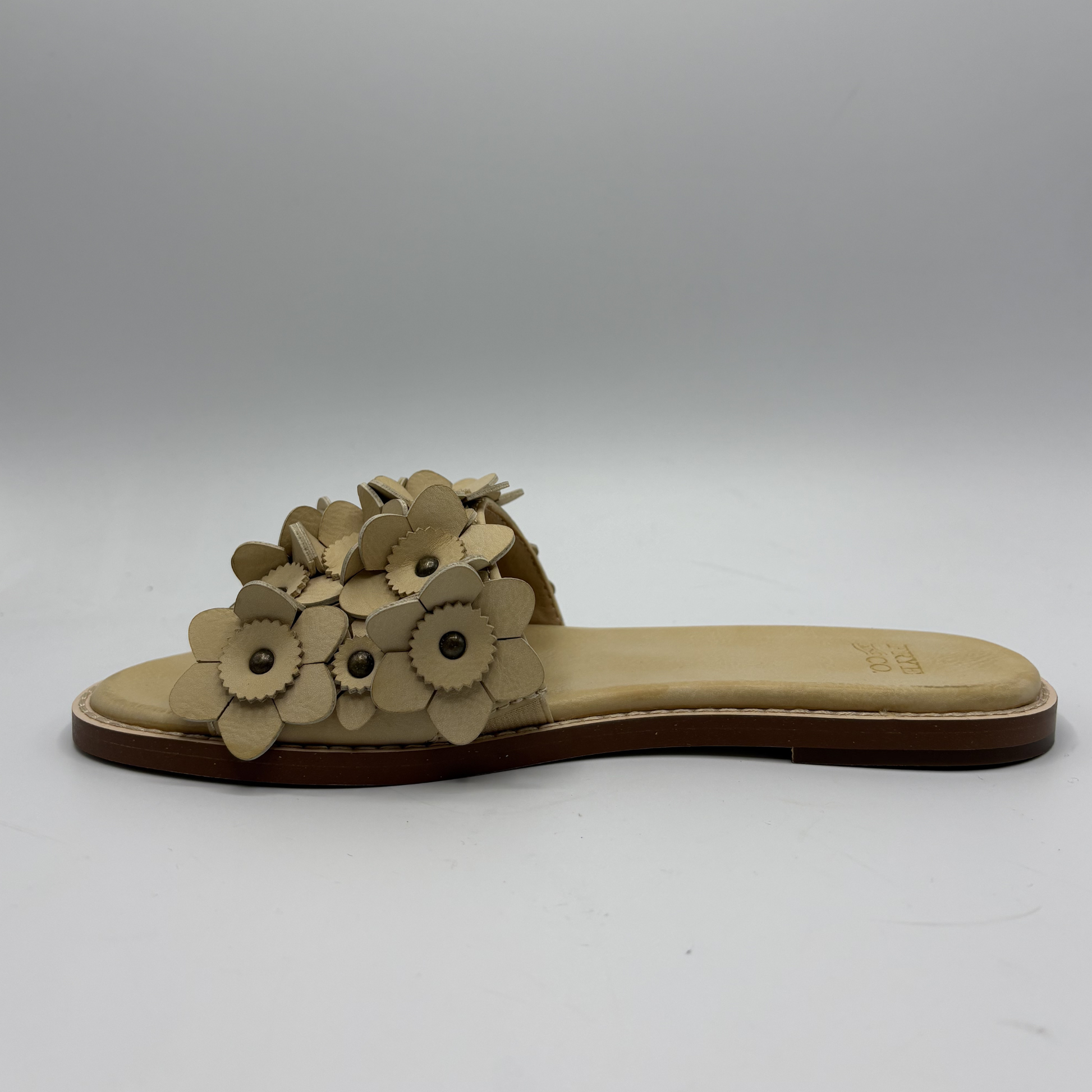 Beige sandal with floral design on a white background