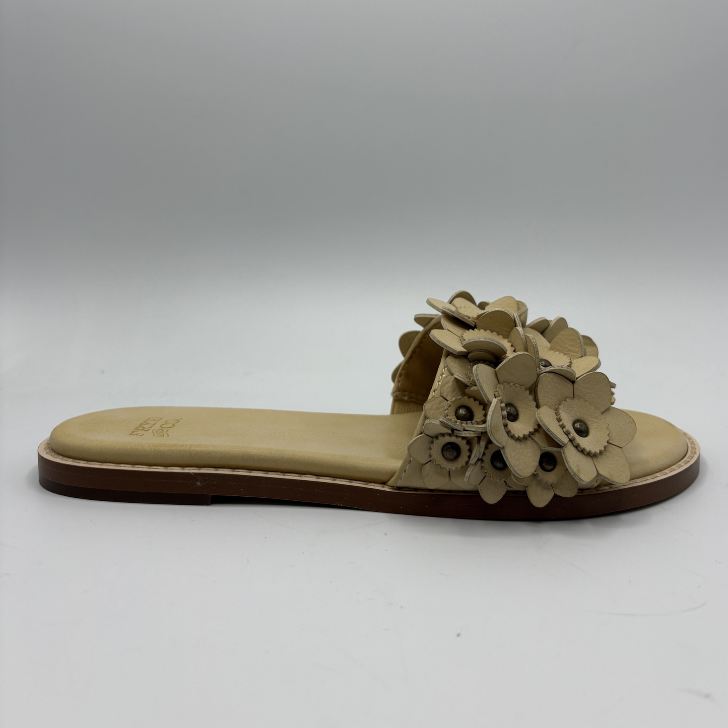 Beige sandal with floral design on a white background