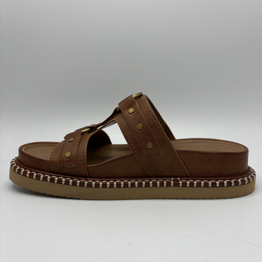 Brown sandal with a textured sole on a white background
