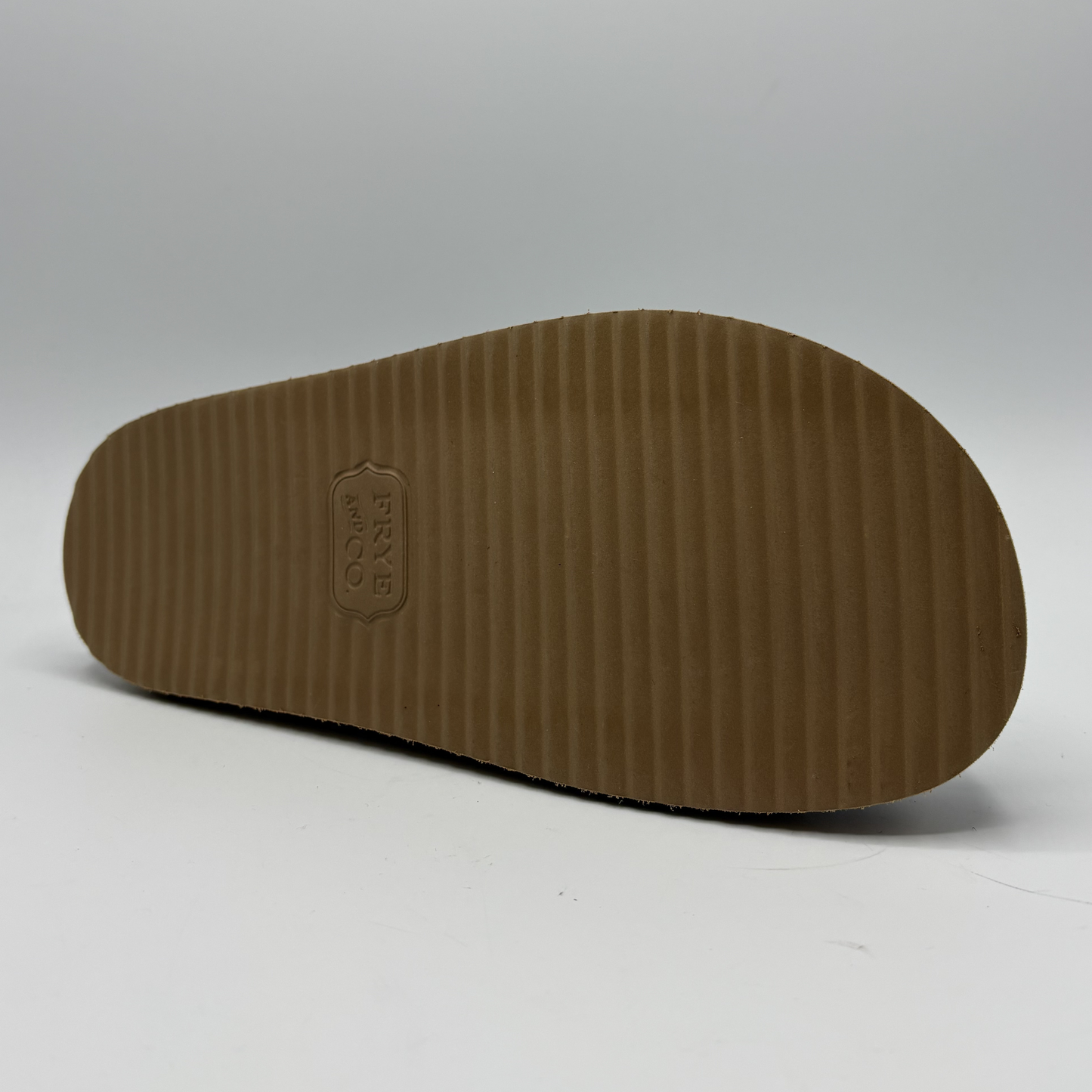 Brown sole of a shoe with a brand logo on a white background