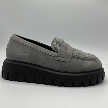 Gray suede loafer with thick black sole on a light gray background