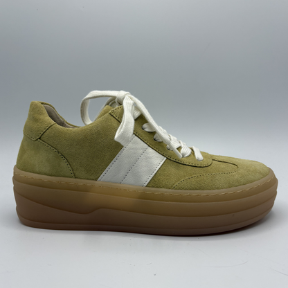 Yellow sneaker with white laces and brown sole on a gray background