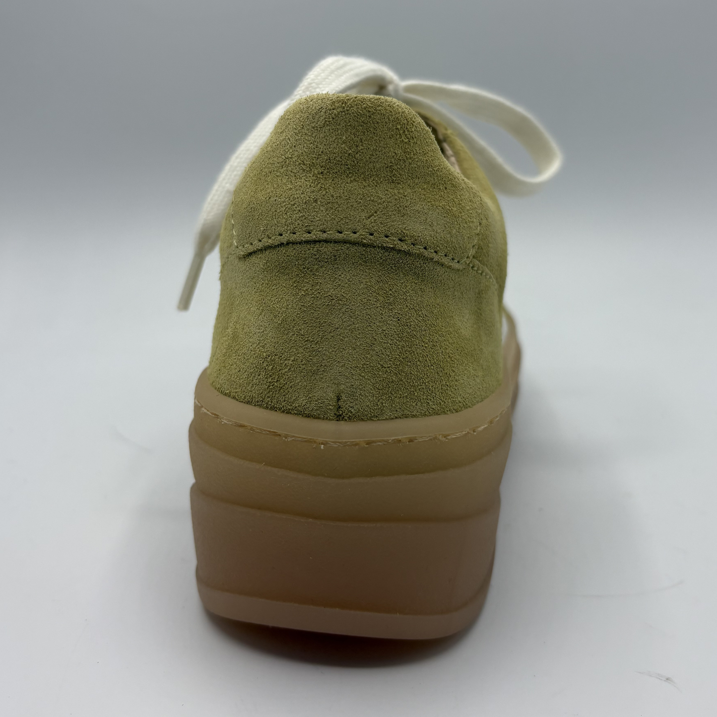 Yellow suede shoe with a brown sole on a white background