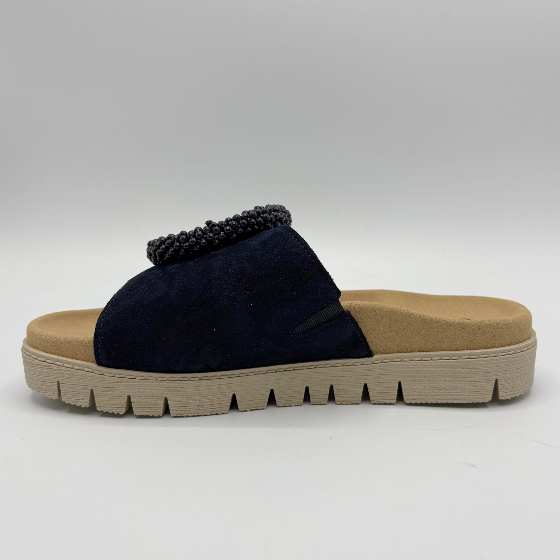 Navy slip-on sandal with a beige sole on a white background