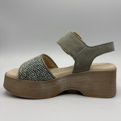 Green sandal with wooden platform on a gray background