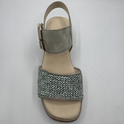 Green sandal with textured strap on a white background