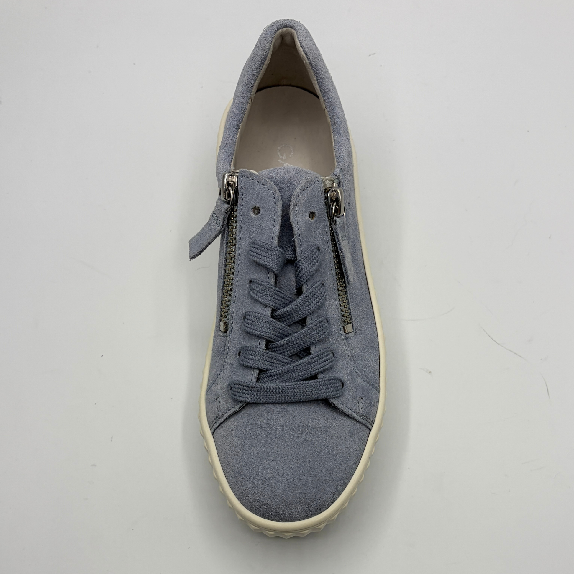 Blue sneaker with zippers on a light gray background