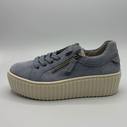 Blue sneaker with a platform sole on a gray background