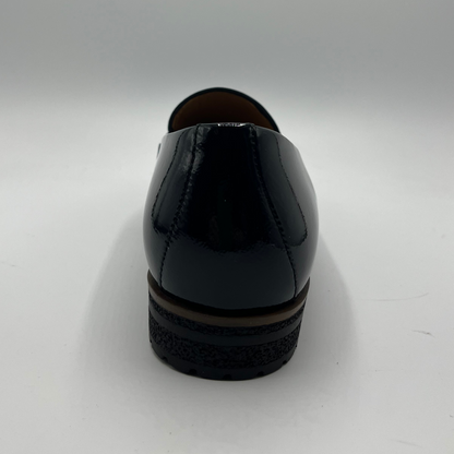 Back view of a black leather loafer with a tan lining