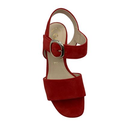 Top view of red high heeled sandal with soft square toe and silver buckle on the strap