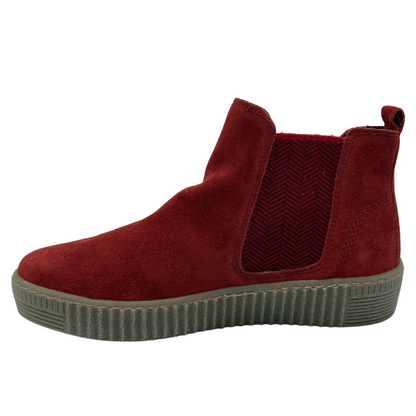 Left facing view of red suede bootie with pull-on tab and rubber sole